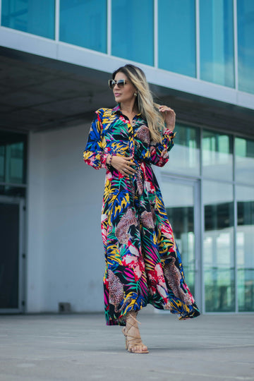 a woman in a colorful dress is standing in front of a building