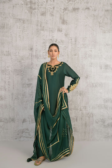 A woman wearing a green and gold dress
