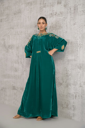 A woman in a green dress standing in front of a wall