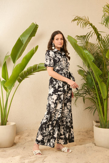 Woman in black and white floral dress with plants