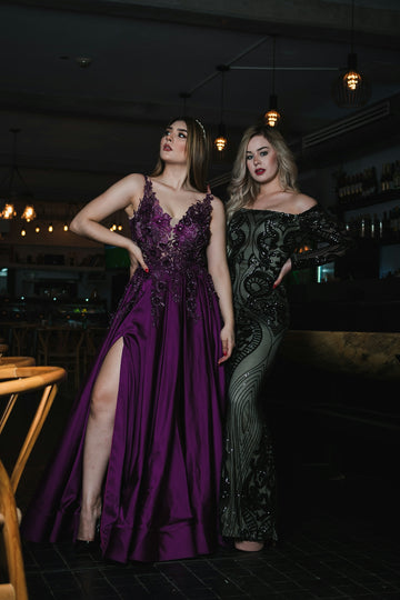 Two women in elegant gowns posing indoors