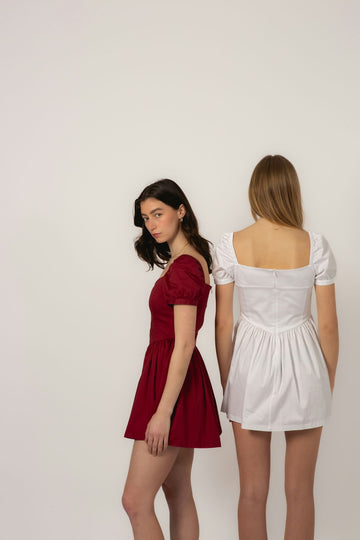 Two young women in dresses against a white background