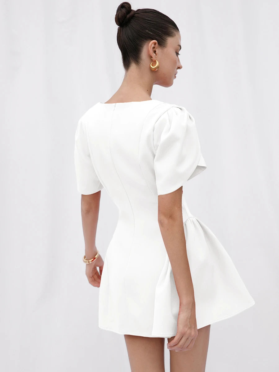 Back view of white mini dress showing center zipper, seams and flared skirt