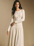 Close front view of the ivory white textured maxi dress showing round neckline, front buttons, and long sleeves