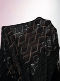 Close-up of black knit dress shoulder showing geometric openwork pattern