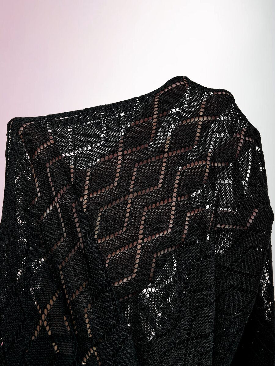 Close-up of black knit dress shoulder showing geometric openwork pattern