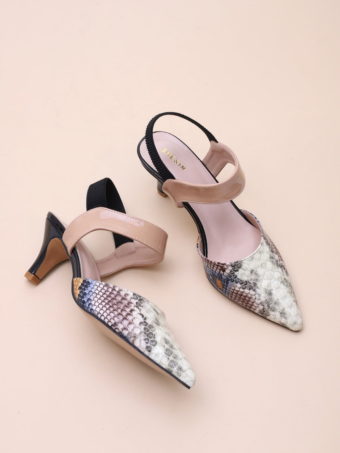Step into style with these chic multi-color snakeskin slingback pumps for women. The stylish pointed toe and mid-high heels make them perfect for the spring and summer. Elevate any outfit and show off your playful side with these quirky and fun pumps. (Pun intended!)