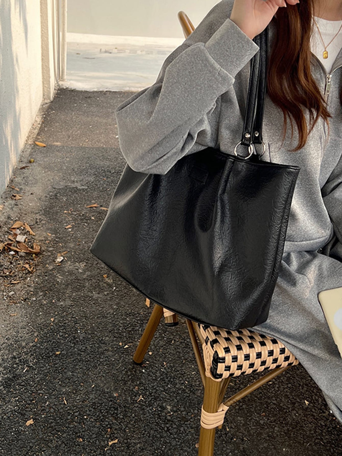 This stylish white shoulder tote bag is the perfect accessory for work and travel. Its sleek design, accentuated by the O-ring detail, makes it both fashionable and functional. Made for the modern woman on the go, it offers ample storage space and can easily transition from day to night.