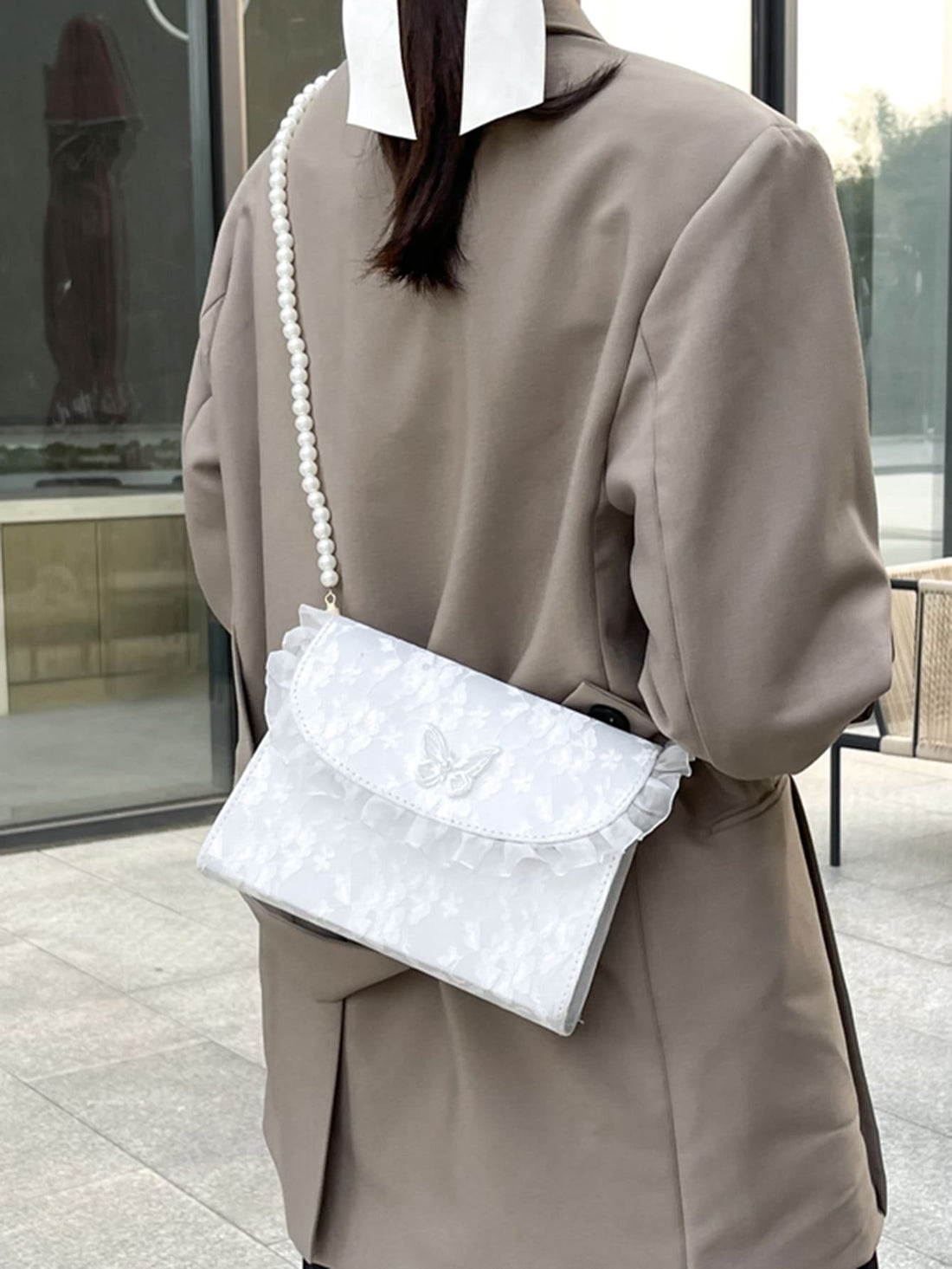 The Chic Butterfly Applique Faux Pearl Trim Square Bag is the perfect accessory for any occasion. With its elegant design and faux pearl embellishments, it adds a touch of sophistication to your outfit. Its square shape and spacious interior make it functional and stylish. Elevate your look with this must-have bag.
