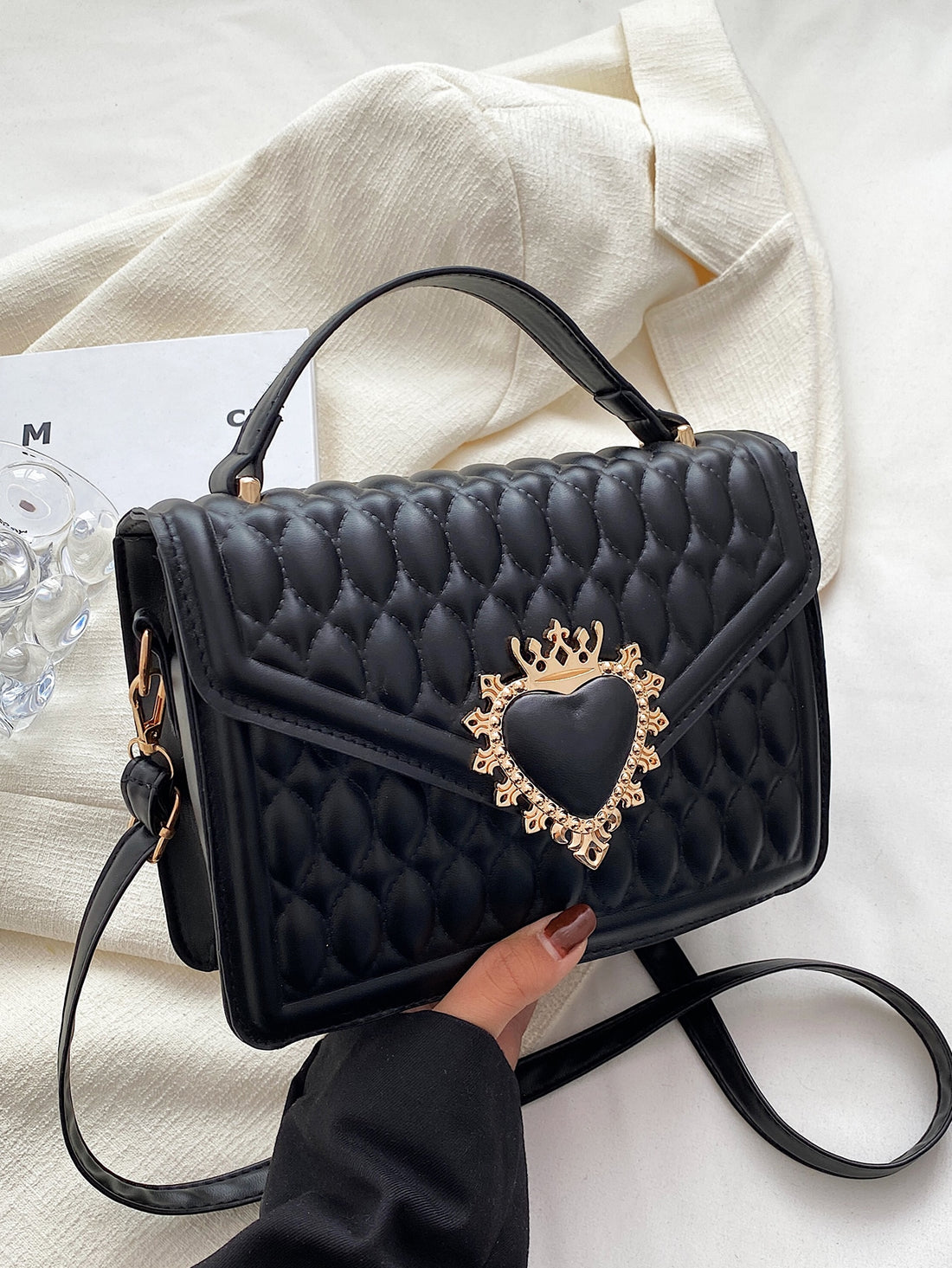 Indulge in the elegance and sophistication of our Quilted Crown Heart Decor Square Bag. This must-have accessory is perfect for the fashion-forward woman with its quilted design and stylish heart decoration. Crafted with precision, this bag is a timeless piece that will elevate any outfit.