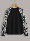 Step up your fashion game with our Wild and Cozy: Contrast Leopard Raglan Sleeve Sweatshirt. Made with soft and comfortable material, this sweatshirt will keep you cozy and stylish. The contrasting leopard print raglan sleeves add a touch of wildness to any outfit. Perfect for any fashion-forward individual.