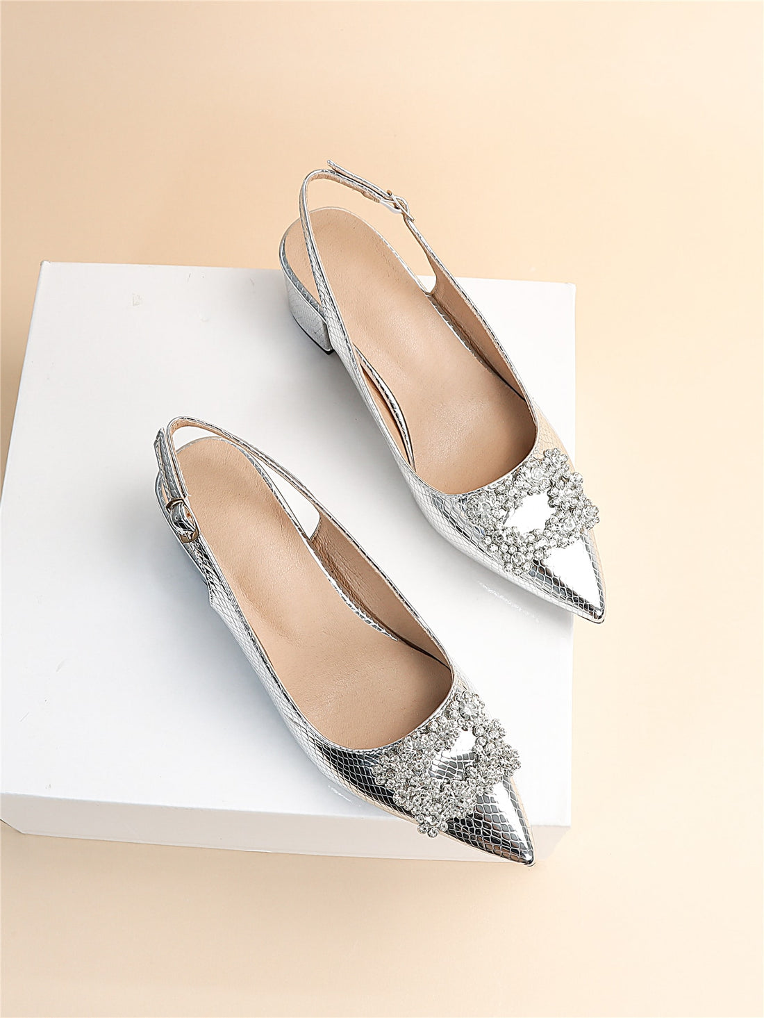 These Silver Serpentine Slingback pumps offer a touch of glamour with their metallic snakeskin design and rhinestone accents. You'll love their unique style and feel confident with their comfortable slingback fit. Elevate any outfit with these statement shoes.