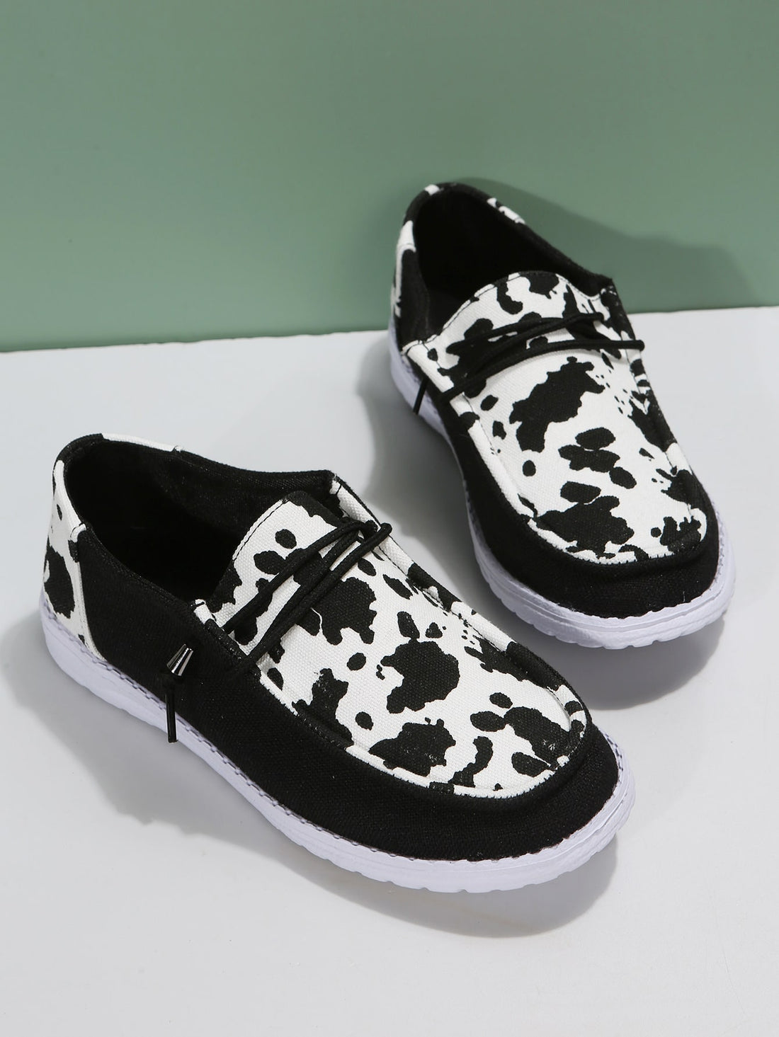 These stylish low-cut canvas sneakers for women feature a unique cow print design and durable lace-up closure. With a comfortable fit and trendy look, they are perfect for any casual occasion. Experience the perfect blend of style and function with these must-have footwear.
