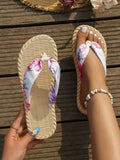 Overhead white and pink floral flip-flops shown worn and held in sunlight