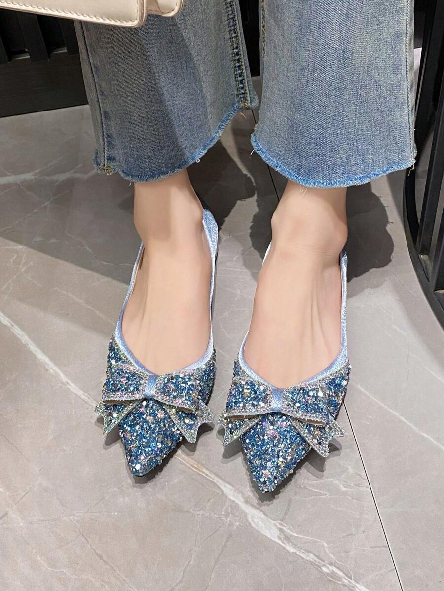 Top view of icy blue jeweled slip-on pumps with symmetrical oversized bows