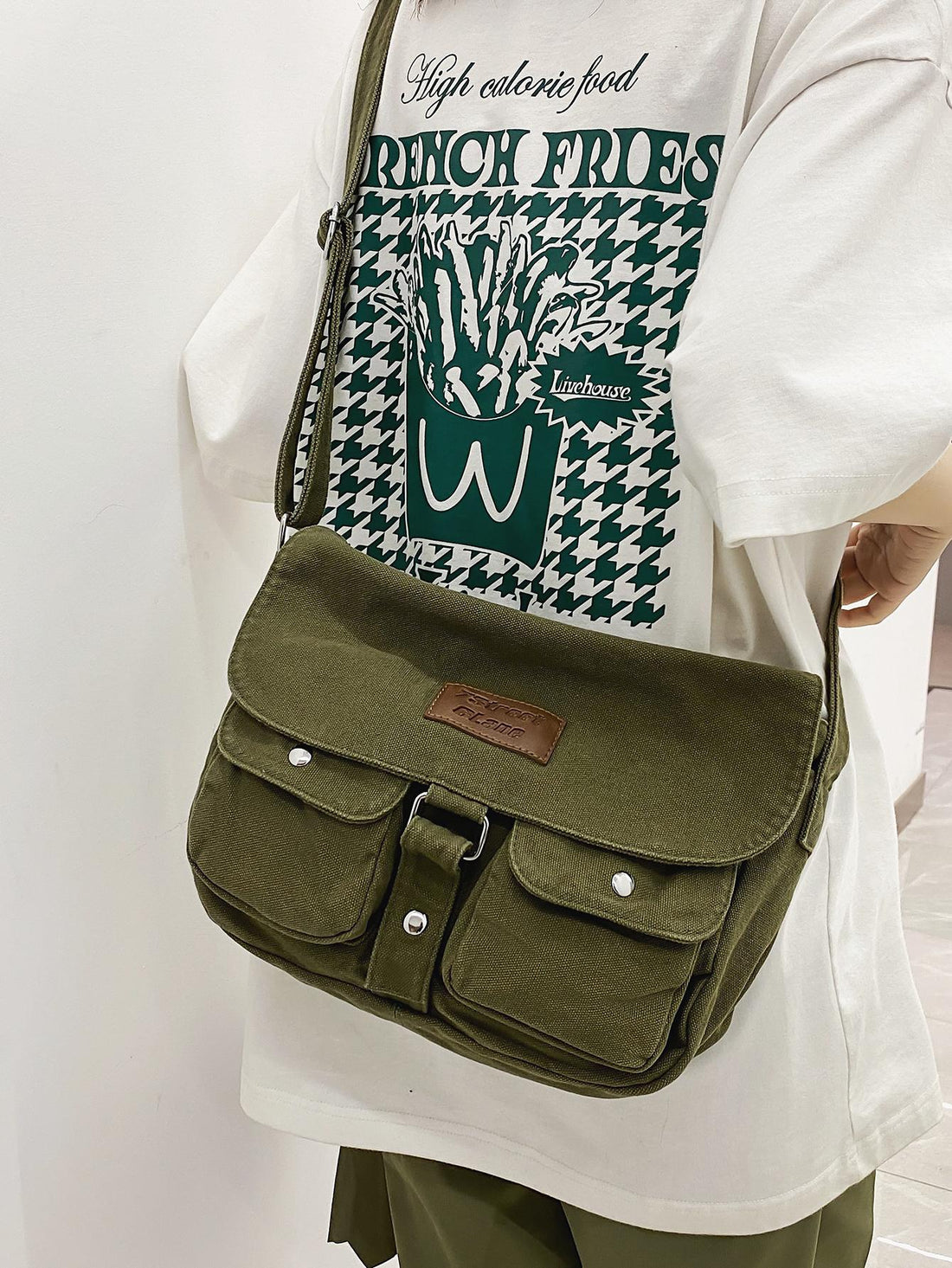 Crafted from durable canvas, this messenger bag combines vintage Japanese aesthetics with practical functionality. The spacious interior accommodates daily essentials, while strategically placed pockets keep smaller items organized and accessible. Its structured silhouette and adjustable shoulder strap provide comfortable, hands-free carrying for work, travel, or casual outings. The retro Harajuku-inspired design adds character to any wardrobe, making it equally suited for fashion-forward styling or underst