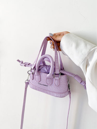 This mini satchel bag combines style and functionality with its crocodile embossed design and double handle for easy carrying. The letter detail adds a touch of chic to any outfit. Perfect for everyday use or a night out.