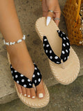 Overhead black polka-dot flip-flops shown worn and held on stone steps