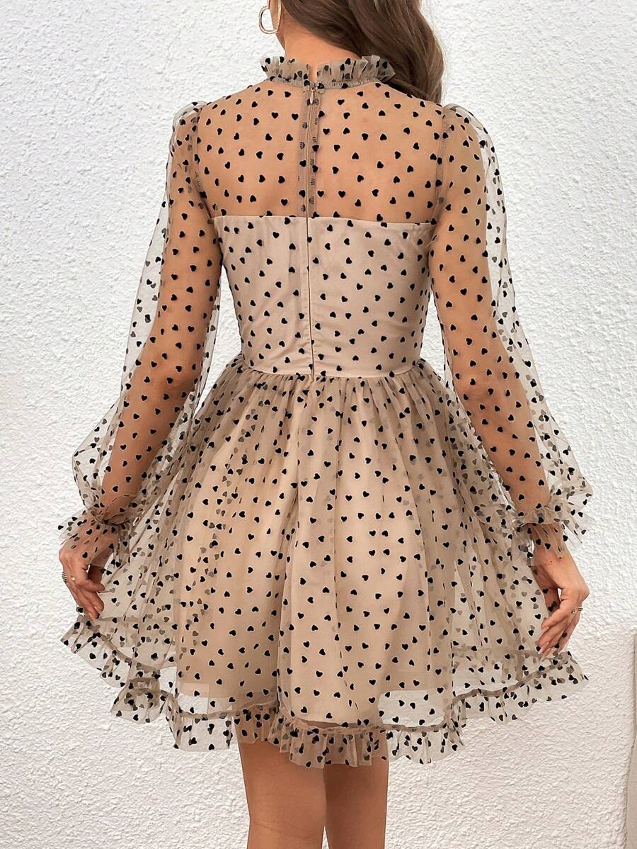 Turn heads with this playful Flirty Heart Print Flounce Sleeve Mesh Dress. Its sheer mesh fabric and charming heart print create a light, whimsical look, while the flounce sleeves add a touch of fun movement. Perfect for those who want to showcase effortless style with a flirty twist.