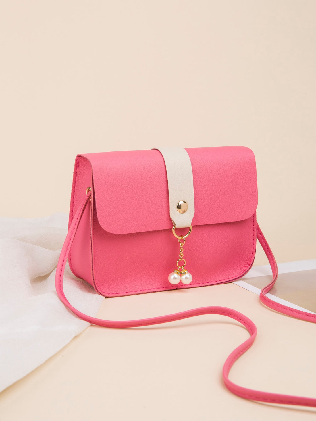 Upgrade your on-the-go style with our chic color block crossbody bag. With a stylish pearl pendant and a mini size, this bag is perfect for any occasion. Stay organized and trendy with this must-have accessory.