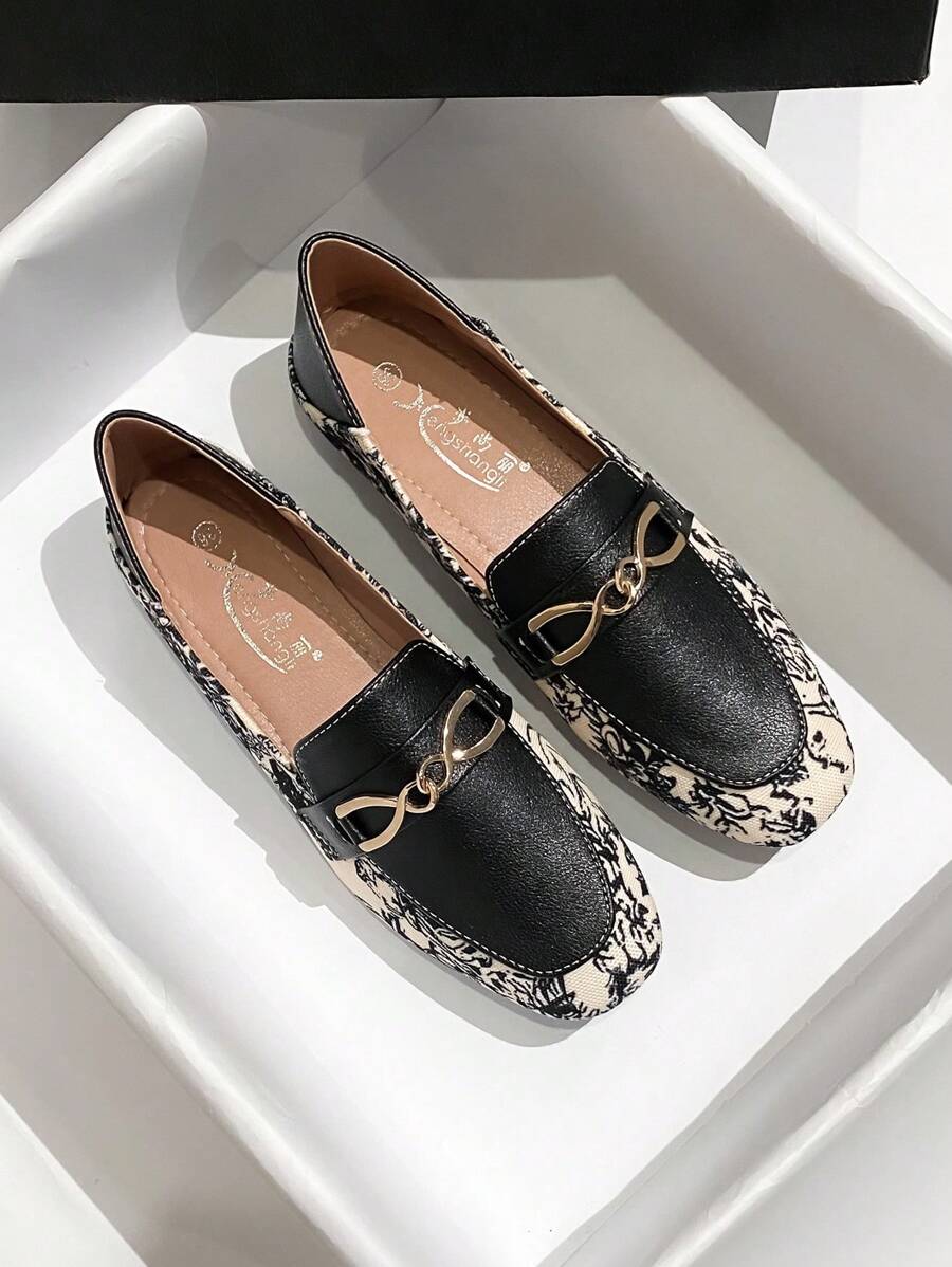 Side view of women printed loafers with black trim and low block heel
