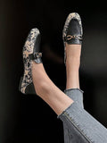 Top view of slip-on loafers showing cream floral print panels and tan insoles