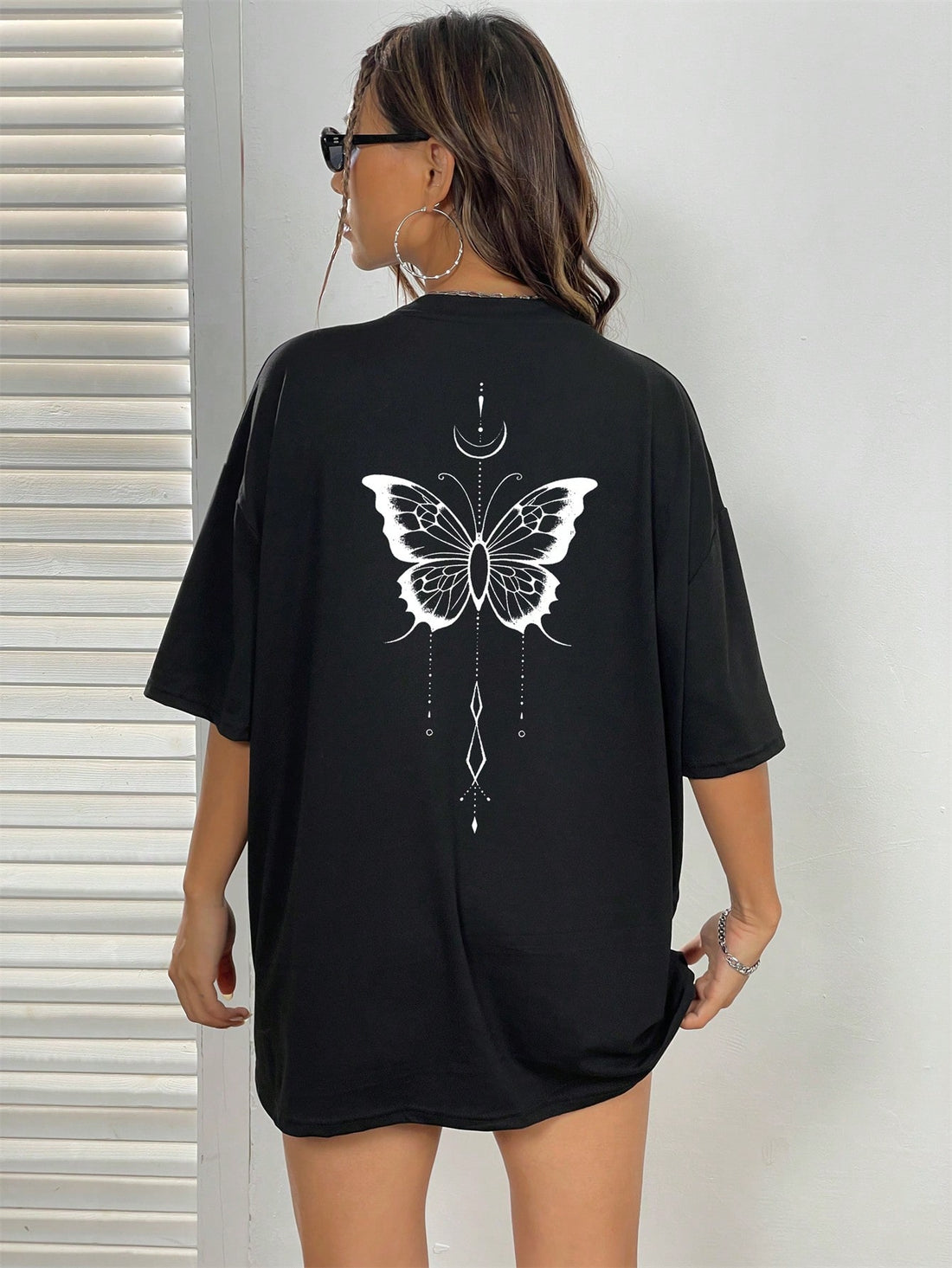 Infuse some whimsical charm into your wardrobe with our Butterfly Print Drop Shoulder Tee. Made from high-quality fabric, this top features a relaxed fit and a playful butterfly print. Perfect for adding a touch of fun to any outfit.