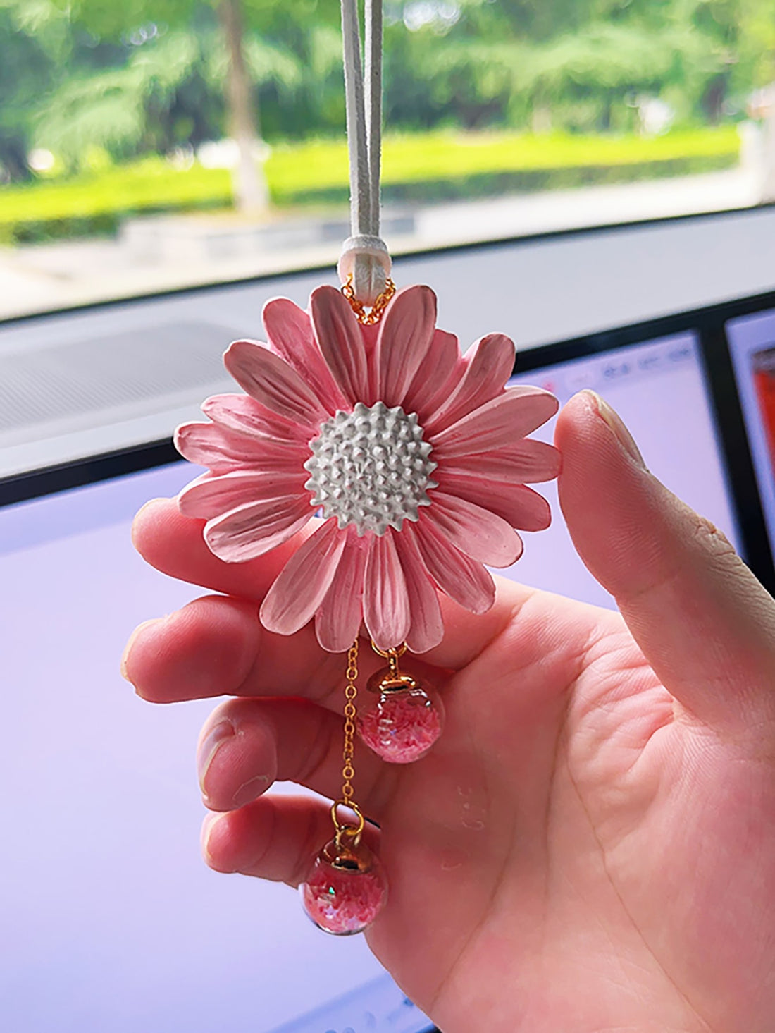 Enhance your car's interior with the Daisy Delight Car Interior Decoration. With a touch of pink on your rearview mirror, your car will feel refreshed and stylish. Made of high-quality materials, this decoration is durable and will add a playful touch to your daily commute.