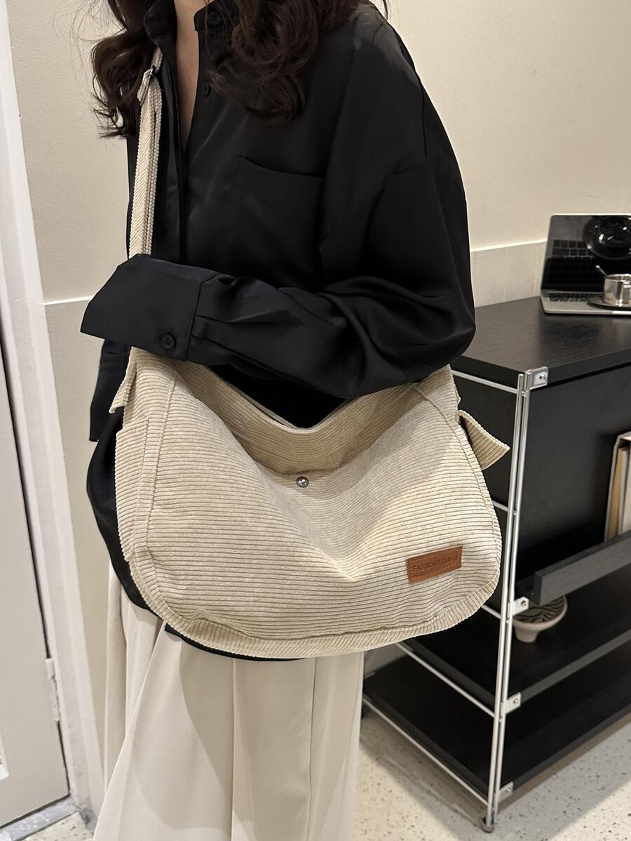 Crafted from durable corduroy fabric, this spacious shoulder bag combines contemporary style with practical functionality. The generous capacity accommodates textbooks, laptops, and daily essentials, making it ideal for students and professionals alike. Multiple compartments keep your belongings organized, while the reinforced shoulder straps ensure comfortable carrying throughout the day. The timeless corduroy texture adds visual interest to any outfit, transitioning seamlessly from campus to casual outing