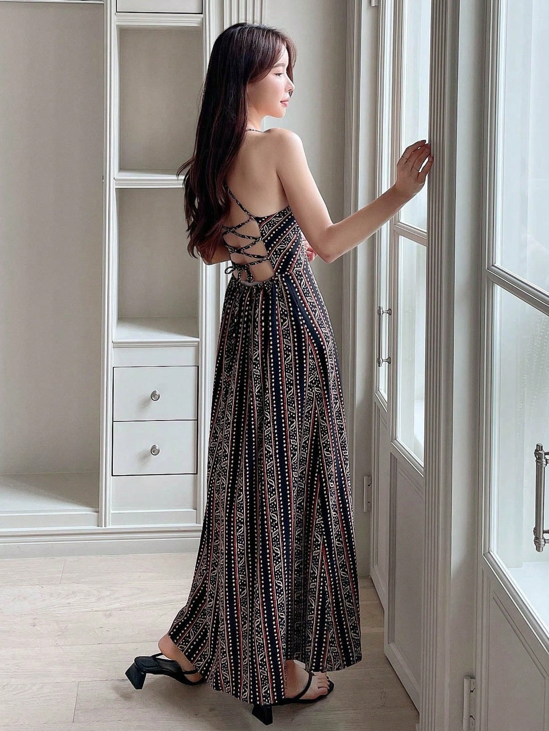 Effortlessly chic for any occasion! This all-over print cami dress features a fun and flirty lace-up backless design, perfect for showing off your playful and stylish side. Stay comfortable and stylish in this unique and versatile dress.