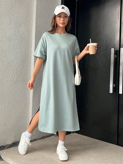 Stay effortlessly stylish in this Mint Green Drop Shoulder Tee Dress with Split Hem. The relaxed drop shoulder design and split hem add a touch of casual charm, while the refreshing mint green color adds a pop of color to your wardrobe. Perfect for any occasion, this dress is a must-have for any fashion-forward individual.