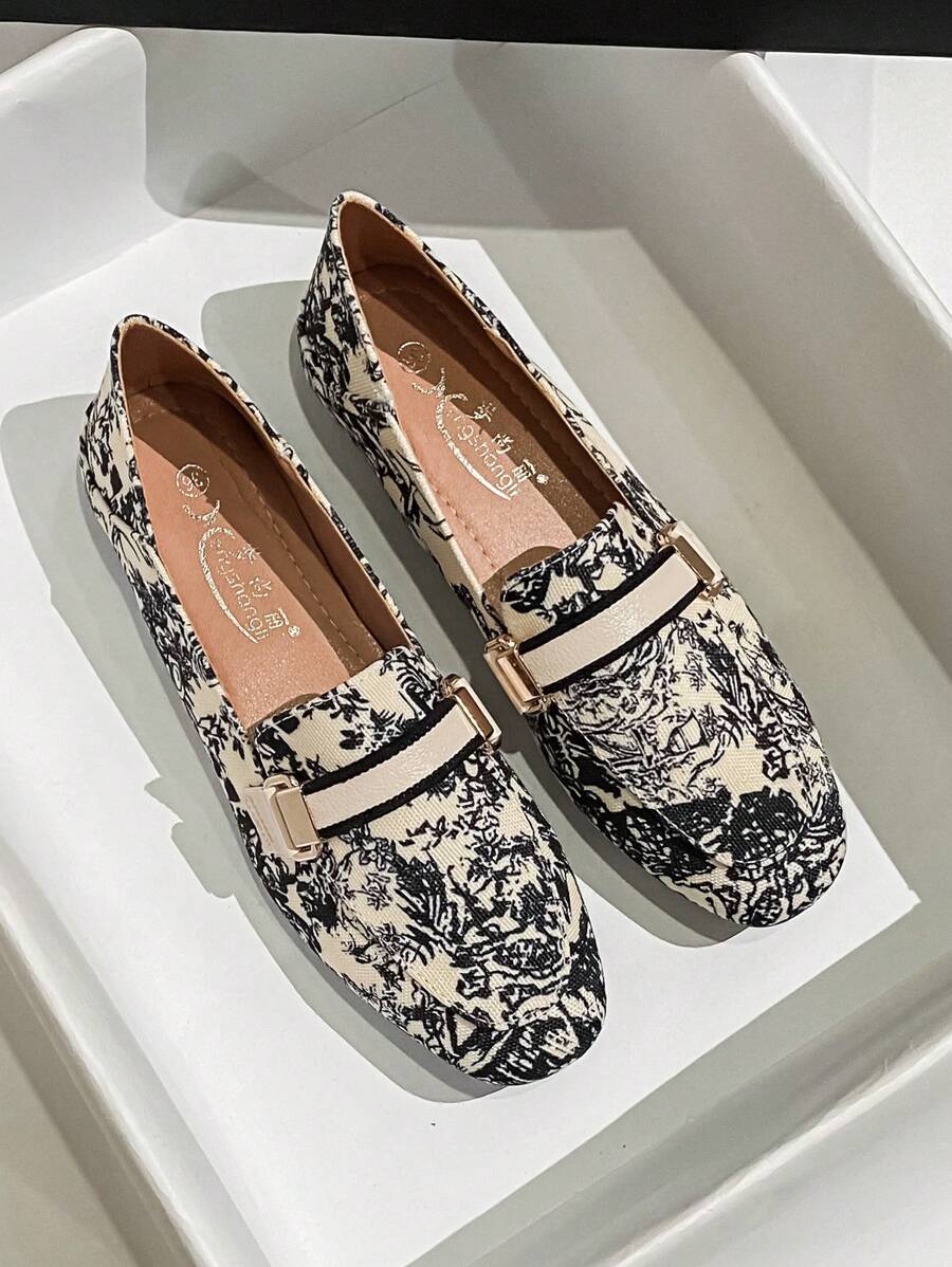 Cream toile print loafer shown in white display tray with black piping