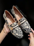 Close-up of cream printed loafer showing square-rounded toe and black trim