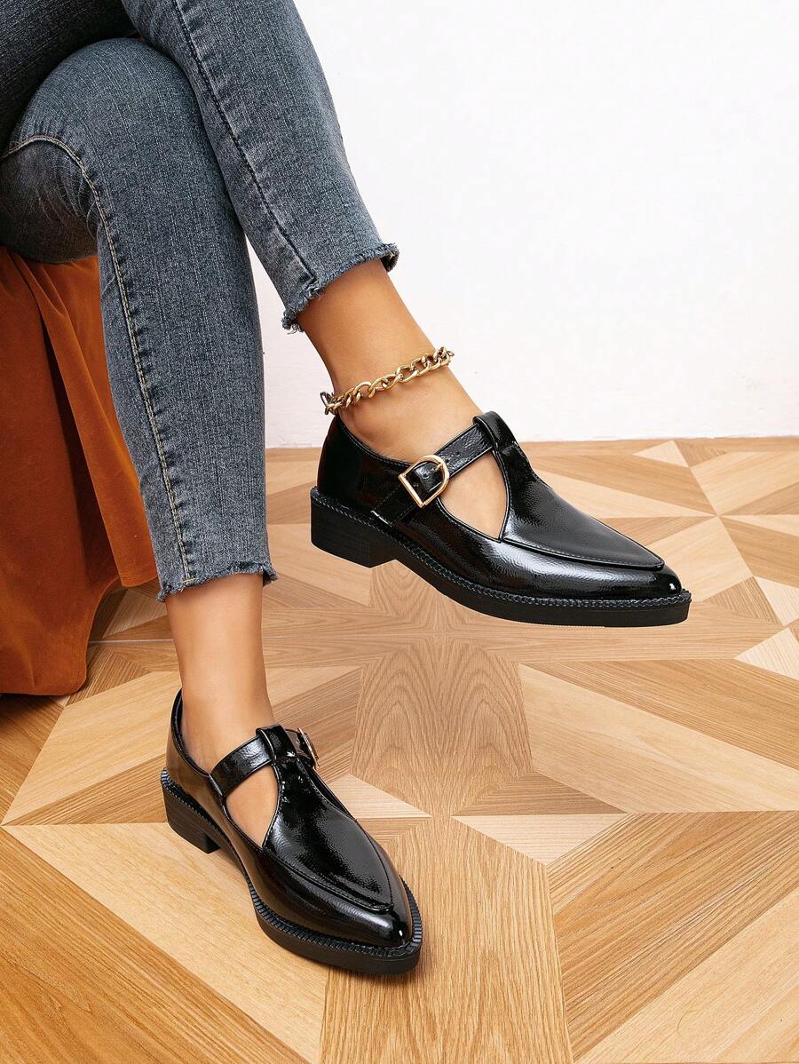 Solid black patent-look Mary Jane pumps worn with jeans in an angled floor view