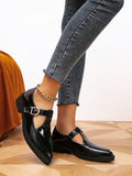 Side and front view of black Mary Jane pumps showing low heels and rubber outsoles