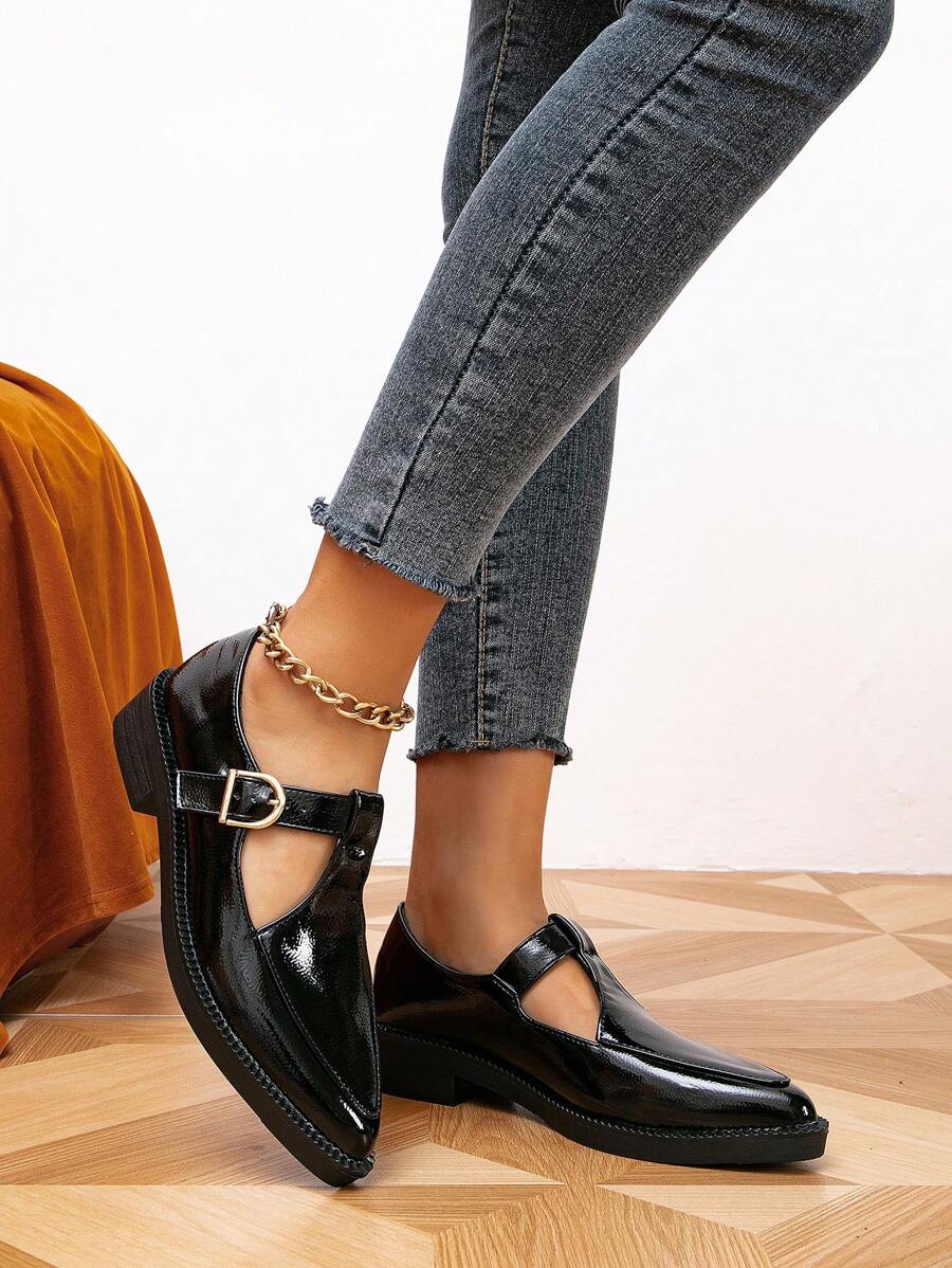 Side and front view of black Mary Jane pumps showing low heels and rubber outsoles