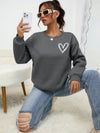 Introducing Heartfelt Comfort's Heart Print Drop Shoulder Sweatshirt. Made with high-quality fabric, this sweatshirt offers a comfortable fit and a stylish heart print design. Perfect for adding a touch of charm to your wardrobe and keeping you cozy all day long. Expertly crafted for maximum comfort and style.