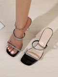 Black rhinestone clear strap mule sandal worn with matching shoe displayed