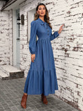 Angled view of denim bow neck dress with button front and ruffle hem