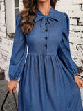 Close detail of blue denim dress with bow tie neckline black buttons and elastic cuff
