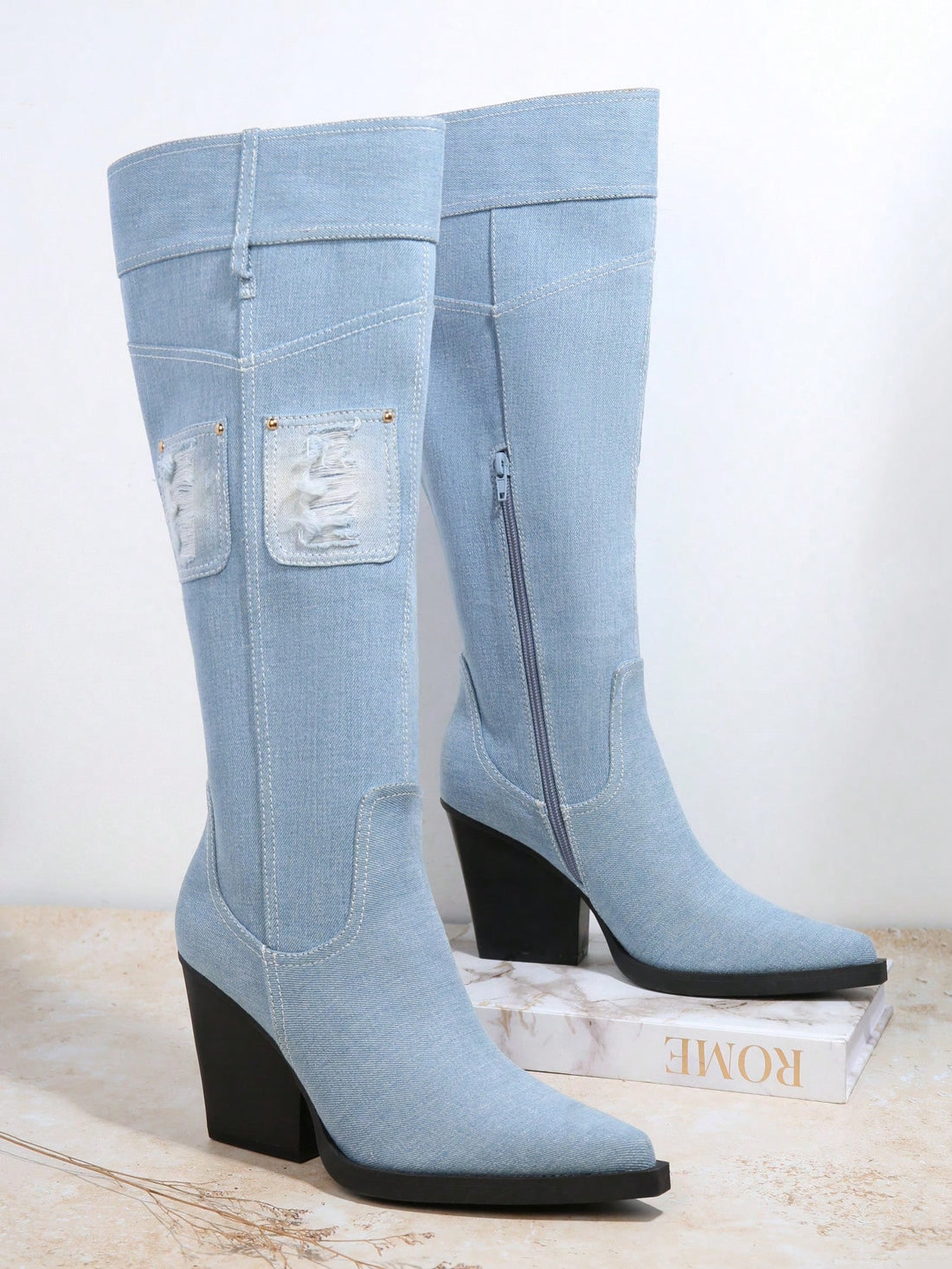 Elevate your style with Rebel Chic's Distressed Patched Block Heel Boots. These boots feature a trendy distressed design with eye-catching patches, adding a touch of uniqueness to any outfit. The chunky block heel adds both height and comfort, making these boots perfect for any occasion.