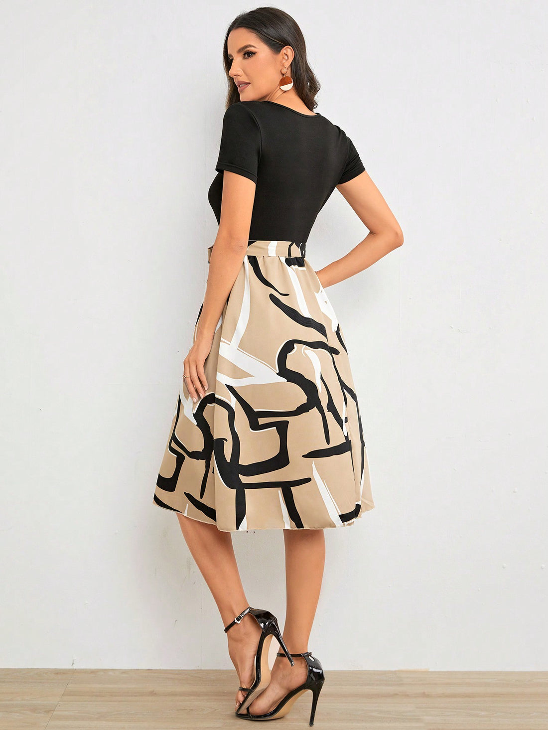 Elevate your wardrobe with our Geometric Graphic Print Belted Dress. Designed with a stylish statement piece in mind, this dress is sure to turn heads. The bold graphic print adds a touch of modernity, while the belted waist flatters your figure. Make a statement with this must-have dress.