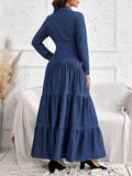 Back view of denim shirt dress showing long sleeves and full tiered skirt