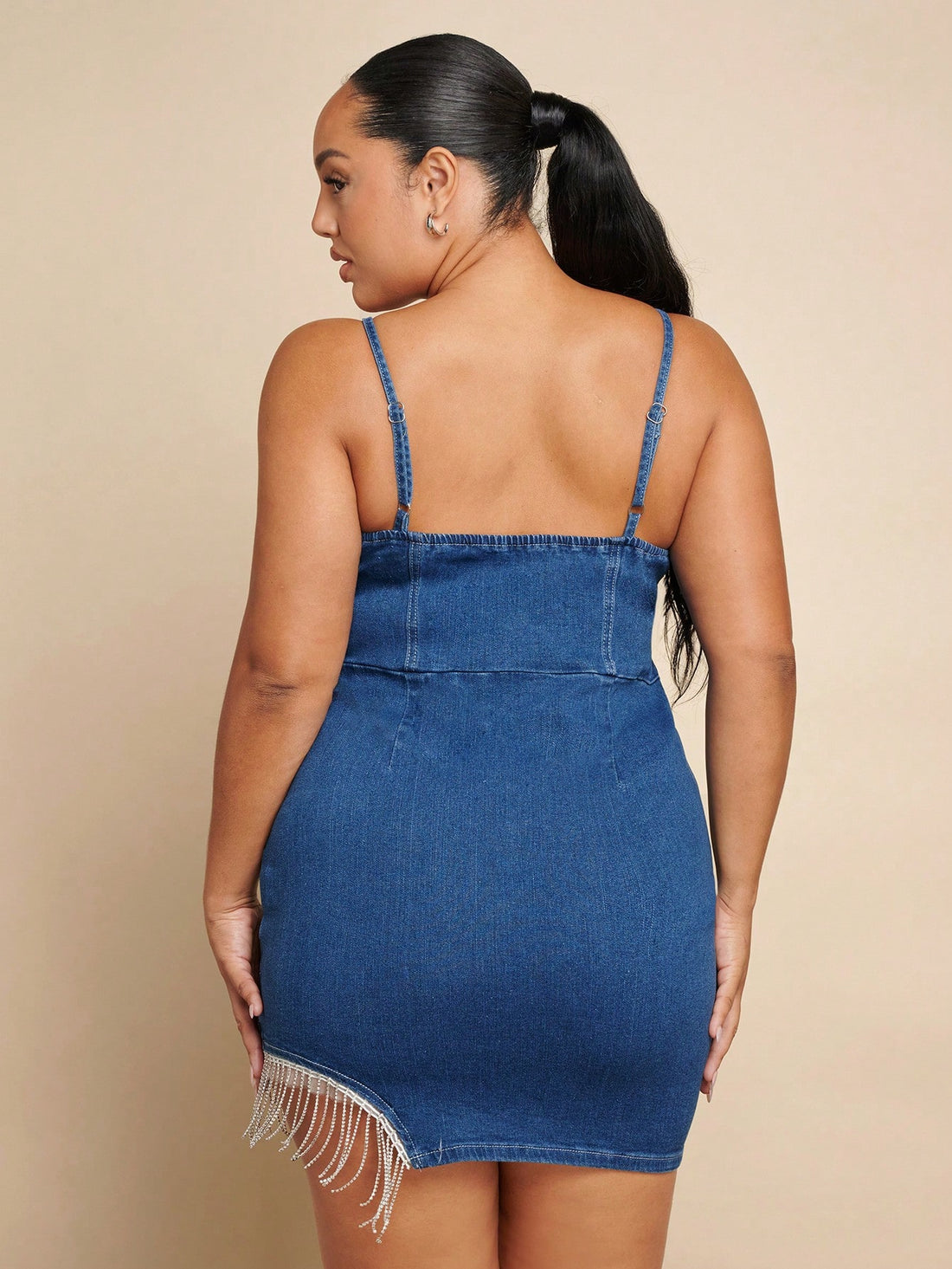 Turn heads with this playful plus size denim dress featuring a sparkling rhinestone fringe hem that adds just the right amount of glam. The strappy design keeps it flirty and fun, perfect for dancing the night away or making a statement at your next outing. Comfortable and stylish, this dress celebrates your curves with confidence and charm.