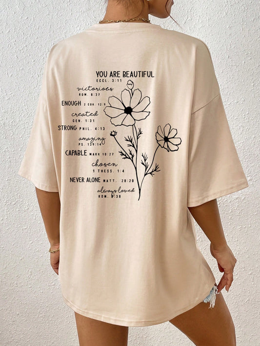 Bloom in Style with this trendy Floral Letter Print Drop Shoulder T-Shirt. Featuring a unique design and comfortable fit, this shirt is perfect for any fashion-forward individual who wants to make a statement. Stay stylish and comfortable with this must-have addition to your wardrobe.