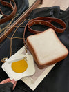 This versatile crossbody bag features a charming bread and egg design, perfect for any occasion. Made with high-quality materials, it offers both style and durability. Its compact size makes it a great choice for carrying essentials on the go. Elevate your fashion game with this delightful duo.