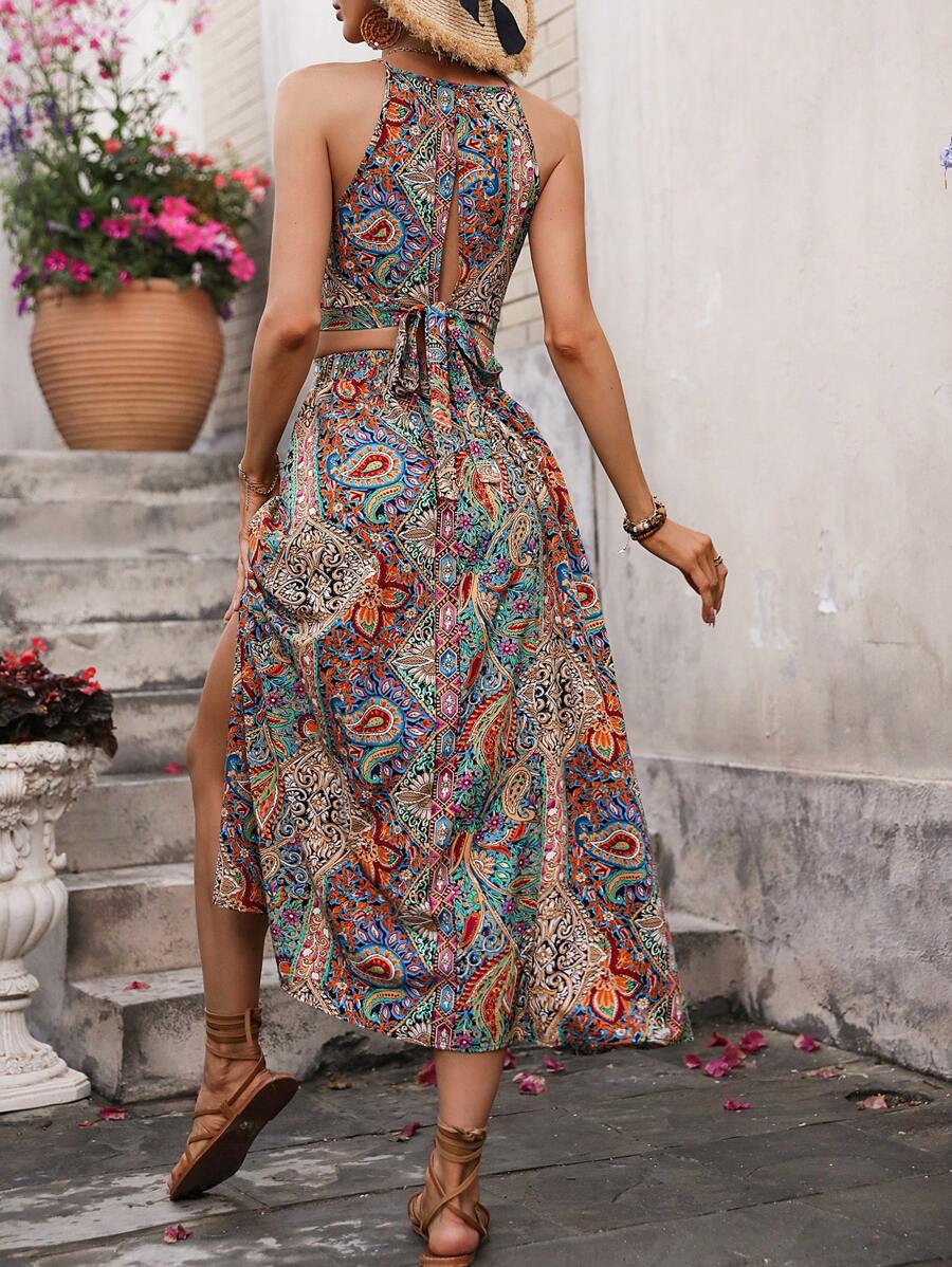 Elevate your wardrobe with this stunning paisley print set featuring a cropped spaghetti strap camisole paired with a flowing long skirt. The boho-inspired design showcases an all-over paisley pattern in vibrant multicolor tones, while thoughtful details like criss-cross straps, a knot accent, and a split thigh hemline add modern flair. Crafted from 100% polyester woven fabric in a regular fit, this versatile two-piece set transitions effortlessly from casual outings to festival celebrations. Machine washab