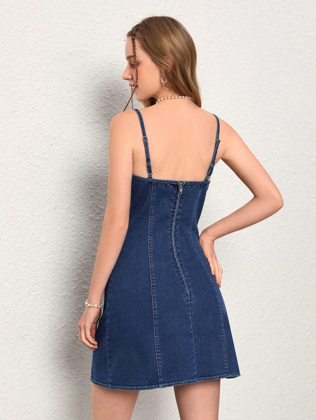 Be effortlessly stylish with our Trendy Tie-Front Denim Cami Dress. This dress is perfect for modern women who want to make a statement. The tie-front detail adds a touch of playfulness to this timeless denim piece. It's a must-have for any fashion-forward wardrobe.
