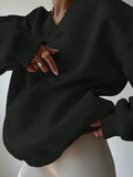 Close front view of black V-neck sweatshirt with loose balloon sleeves and rib-knit trim