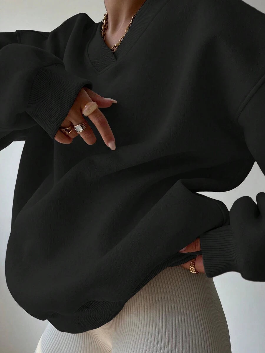Close front view of black V-neck sweatshirt with loose balloon sleeves and rib-knit trim